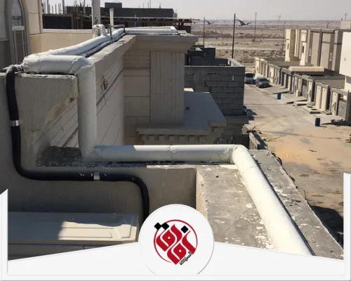 عزل مواسير المياه الساخنة بالقطيف 0559915333 افاق المملكة عزل مواسير المياه الخارجية فوق سطح المبنى، حيث تظهر الأنابيب مغطاة بالكامل بطبقة عازلة بيضاء سميكة