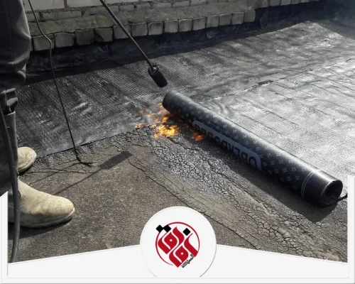 شركة عزل اسطح بصفوى 0559915333 شركة افاق المملكة عامل يركب لفائف العزل البيتوميني على سطح خرساني باستخدام اللهب لتثبيتها ومنع تسرب المياه.